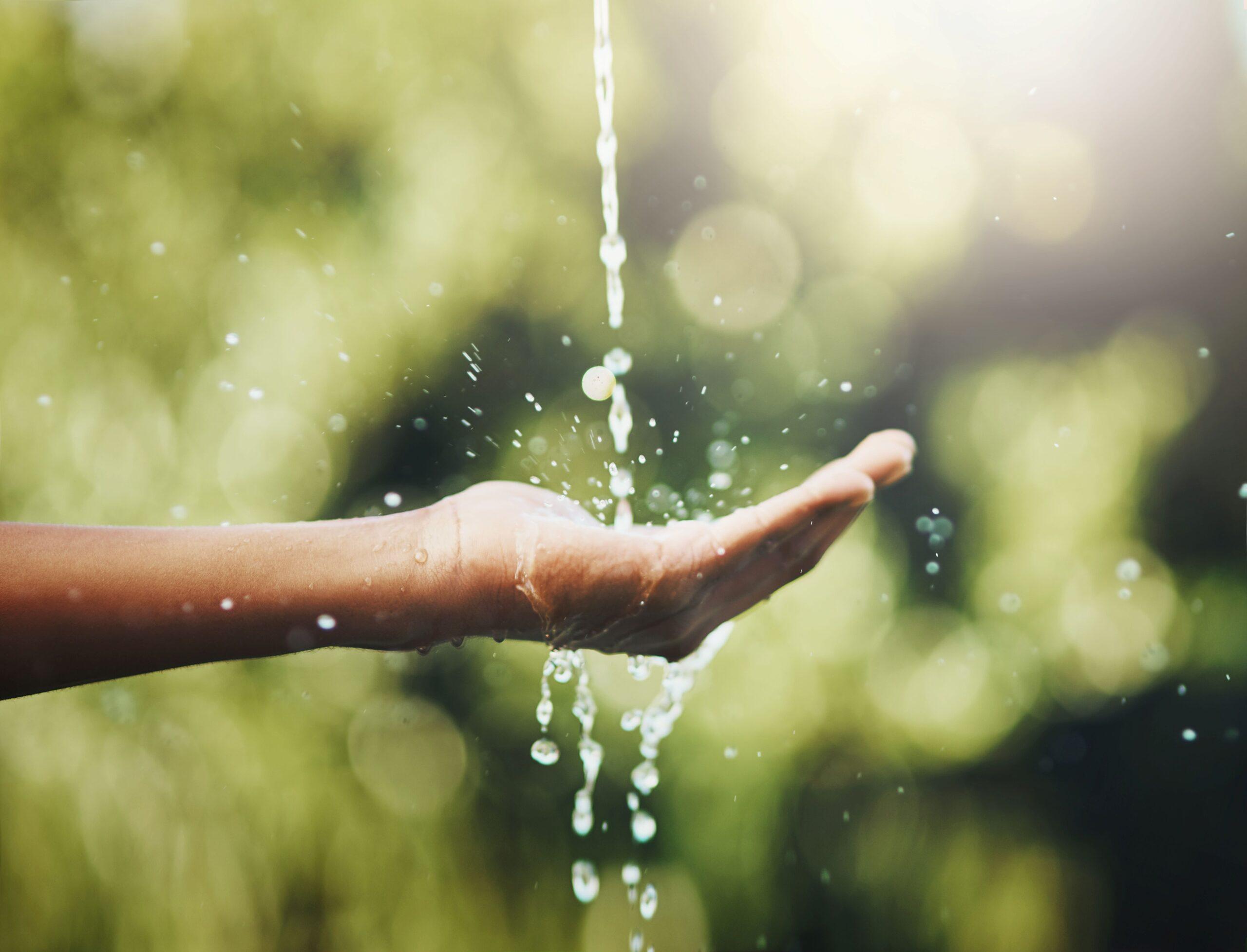 Eine Person hält ihre Hand unter einen Wasserhahn 